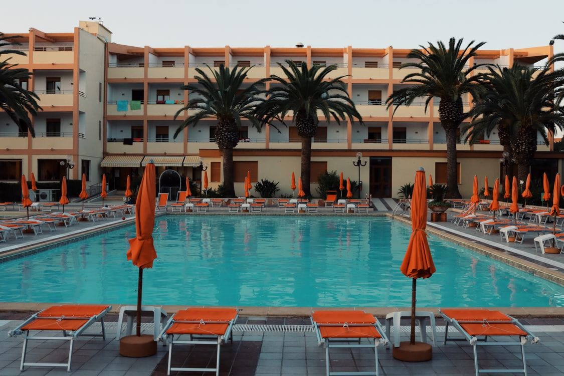 Poolside sunbeds and palm trees at a Mediterranean resort