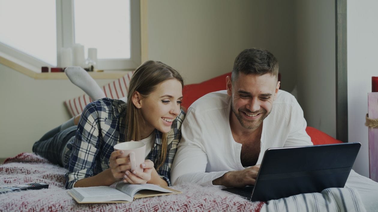 A couple searching for easyJet Holidays packages on a laptop at home