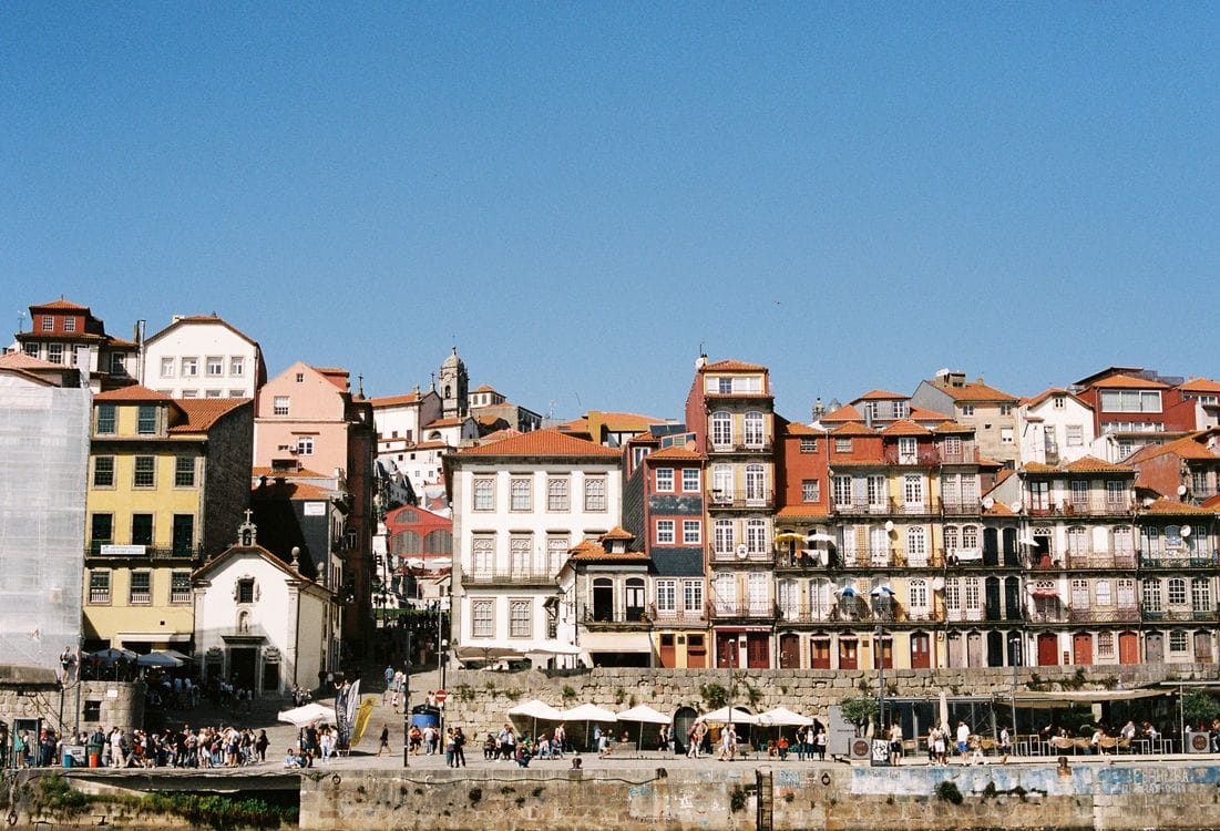 Colourful historic buildings and tiled facades lining a narrow street in Porto's Ribeira quarter