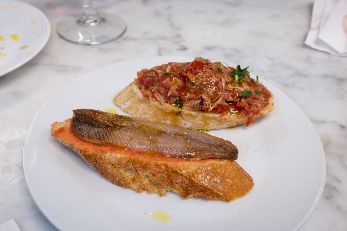 Selection of Spanish tapas dishes on a marble table in a Seville bar