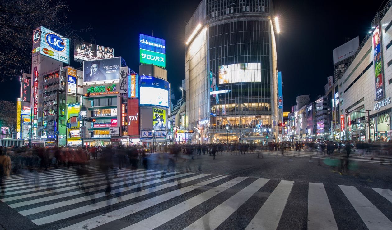 Shibuya Crossing at night with crowds and neon lights in Tokyo