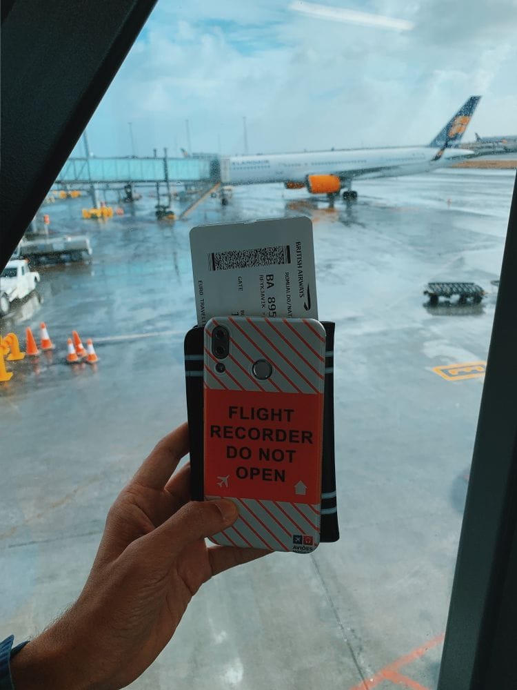 Traveller holding a mobile phone with a boarding pass and travel documents at the airport