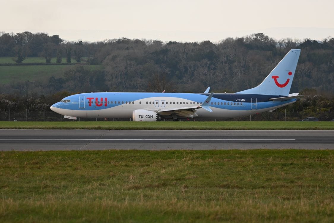 TUI airplane taxiing on the runway at a scenic airport