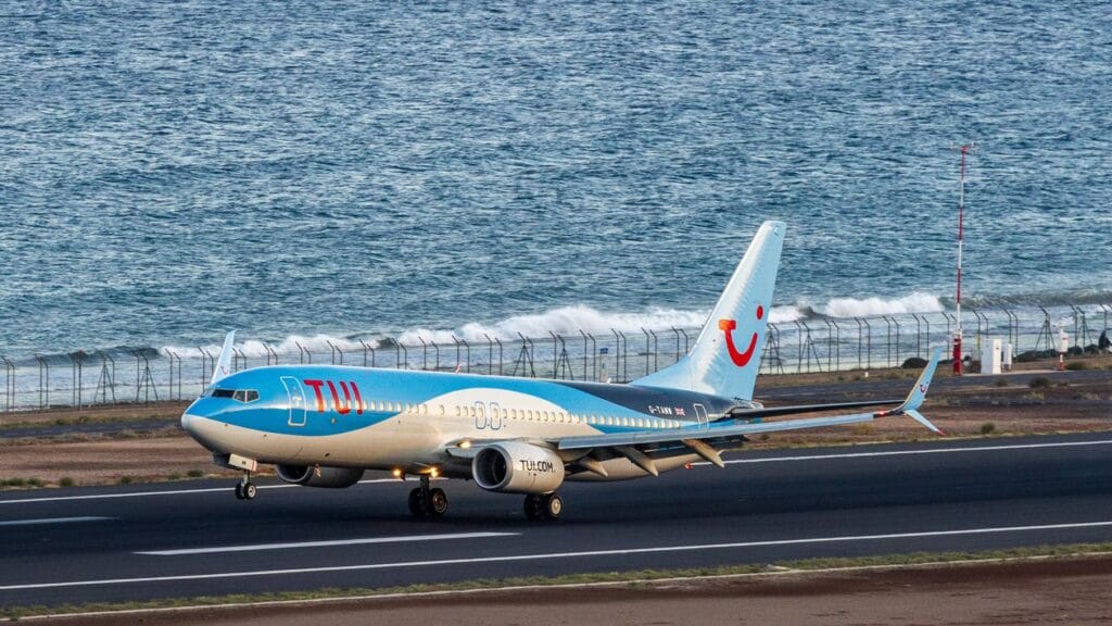 TUI Airways Boeing 737 on runway near the ocean in Spain, white and red livery