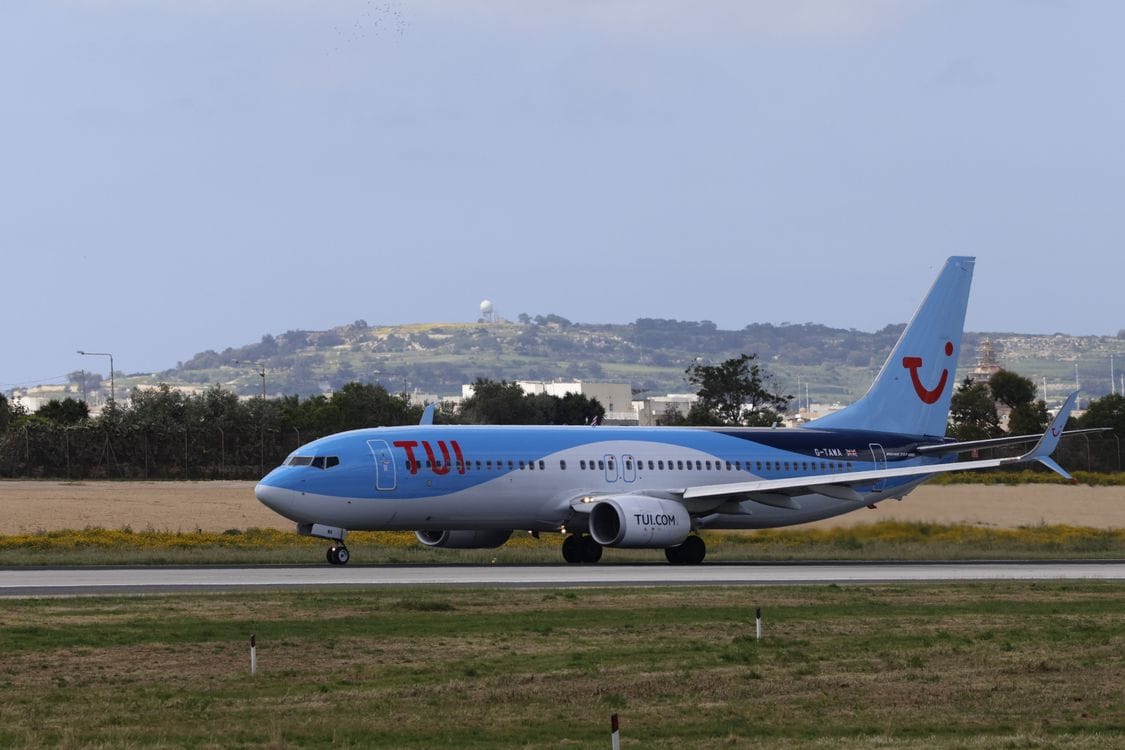 TUI aircraft on runway with scenic hills in background