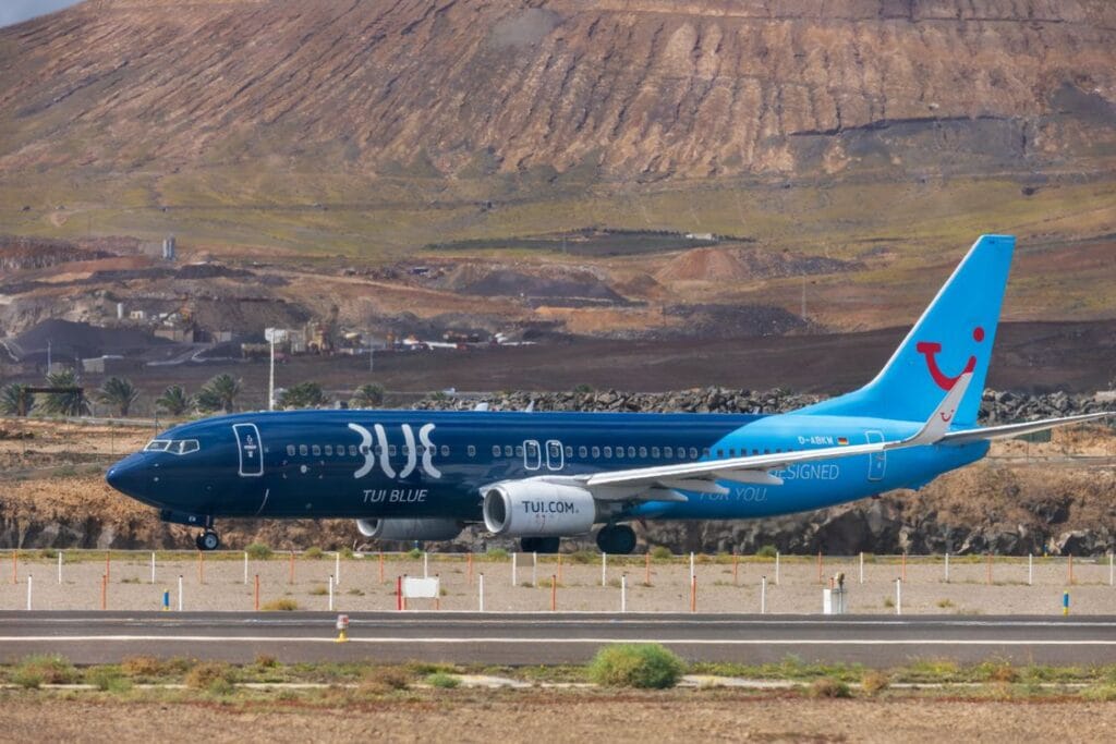 TUI airplane on runway at Lanzarote Airport with mountain backdrop