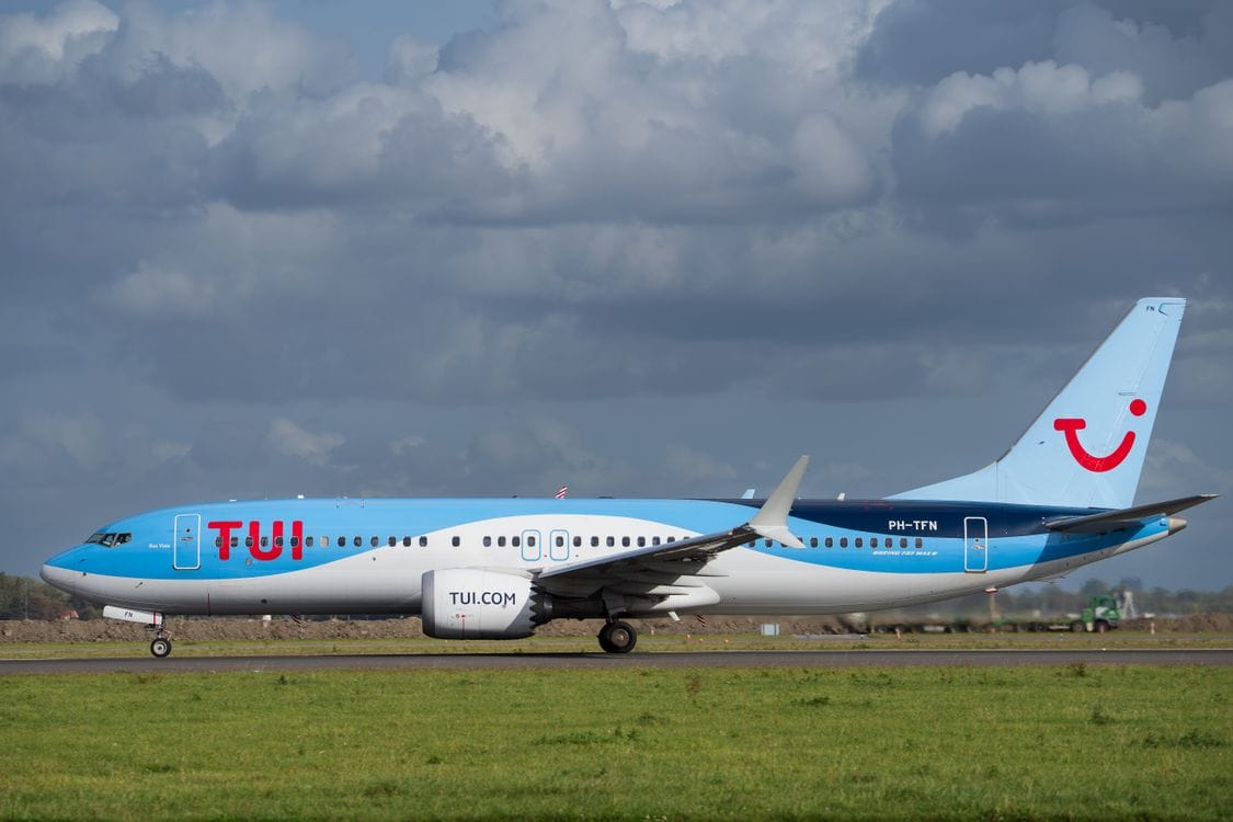 TUI Airlines jet on runway under cloudy sky