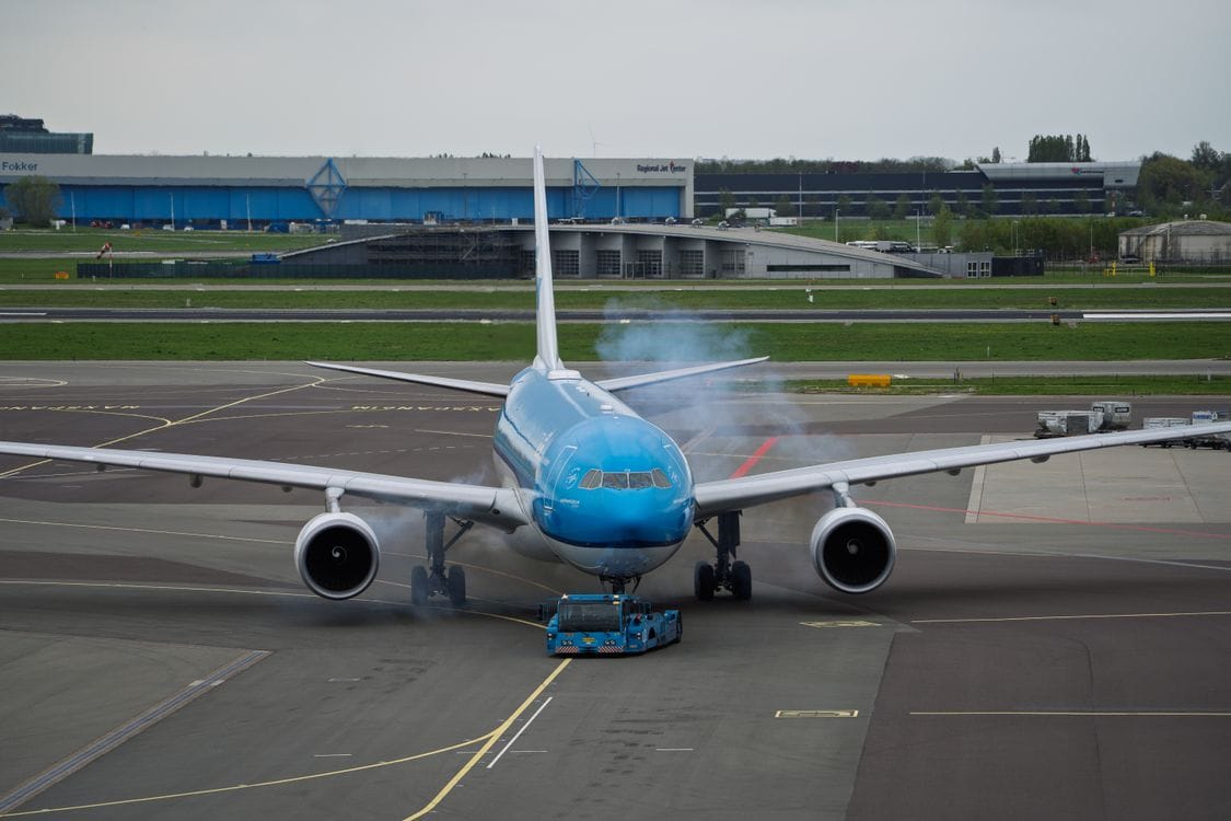 Commercial aircraft taxiing on the runway at Amsterdam Schiphol Airport