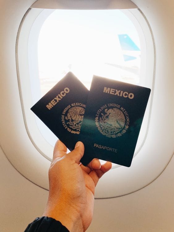 Hand holding passports at an airport plane window — TUI travel insurance