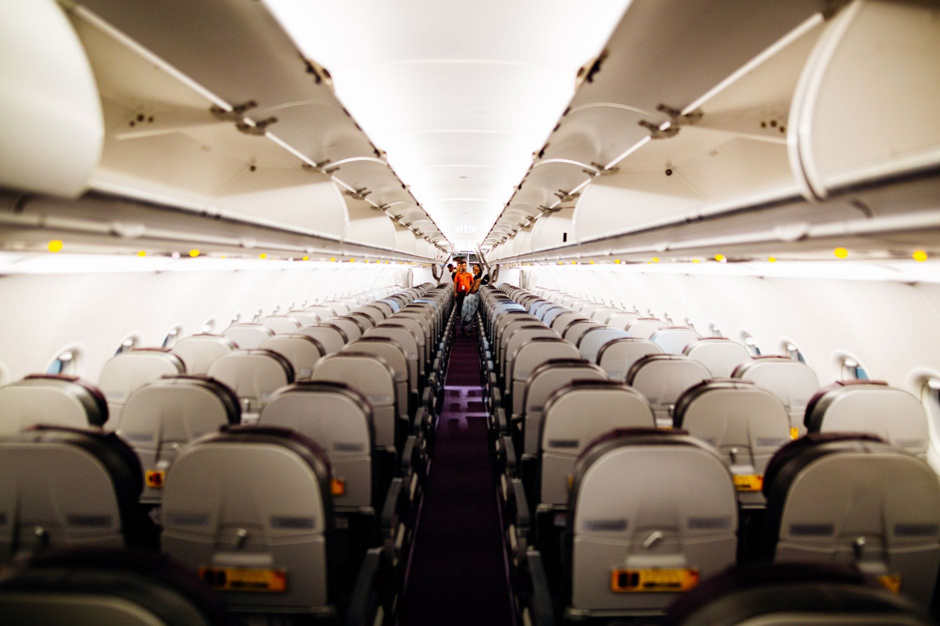 Empty airplane cabin showing rows of seats and overhead bins on a long-haul aircraft