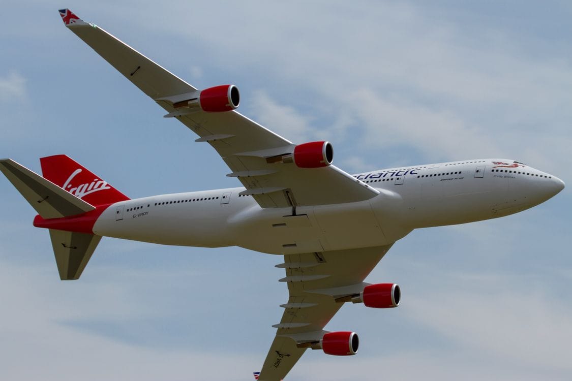 Virgin Atlantic Boeing 747 in flight, red engines and VA fuselage text visible against grey sky