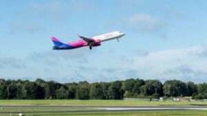 Wizz Air aircraft taking off from a sunny green runway illustrating when does Wizz Air release flights
