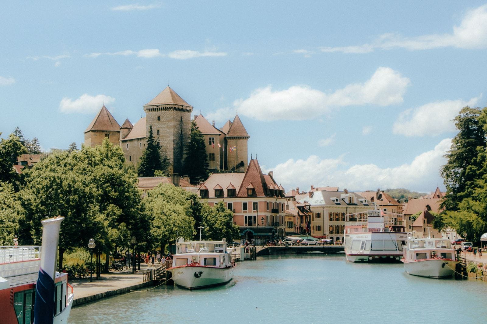 Boats moored on the canal beside Chateau d'Annecy in France