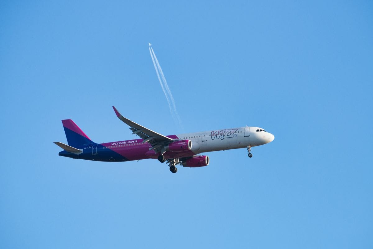 Wizz Air aircraft descending to land against a cloudy sky, illustrating are Wizz Air flights refundable guide