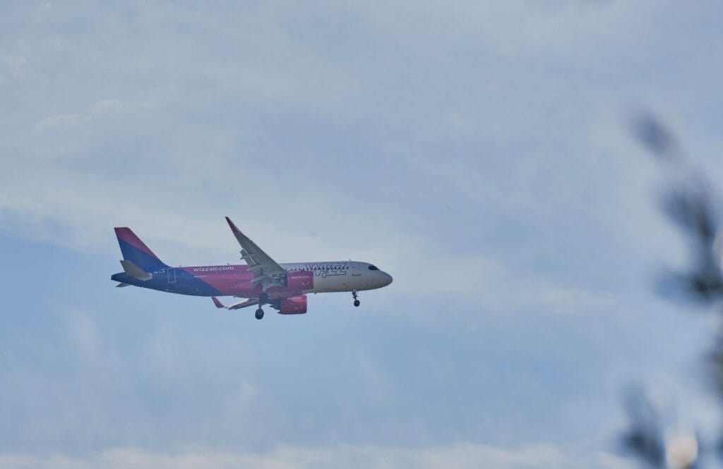 Wizz Air aircraft descending to land against a cloudy sky, illustrating are Wizz Air flights refundable guide