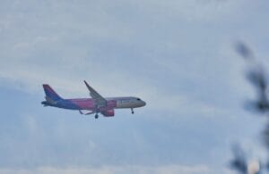 Wizz Air aircraft descending to land against a cloudy sky, illustrating are Wizz Air flights refundable guide