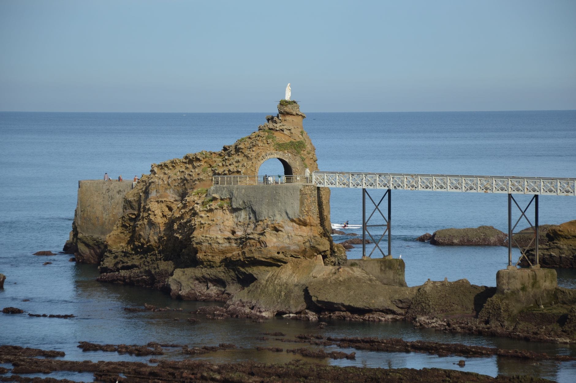 The Rocher de la Vierge rock formation in Biarritz, topped with a statue and linked by a footbridge
