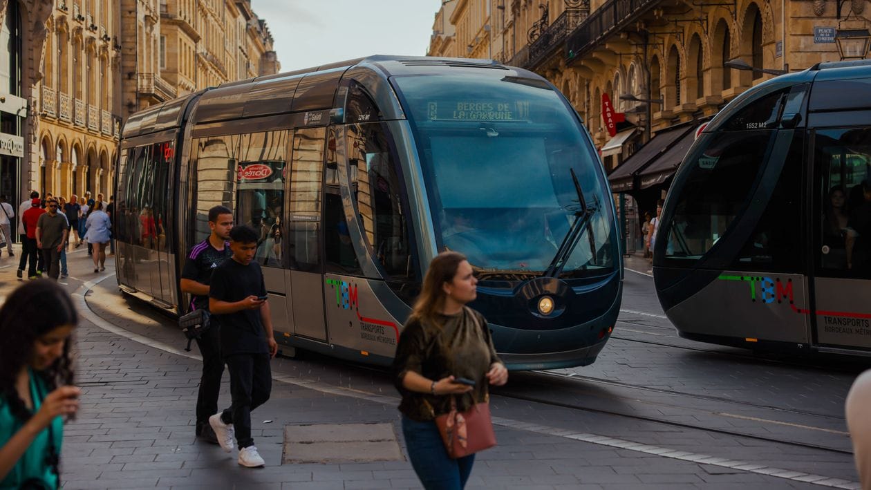 A modern TBM tram passing through central Bordeaux, France