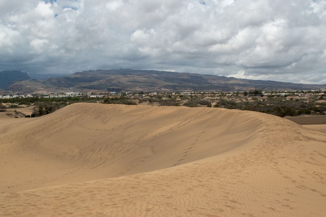 Sand dunes at Maspalomas, Gran Canaria, with the island's mountainous interior behind