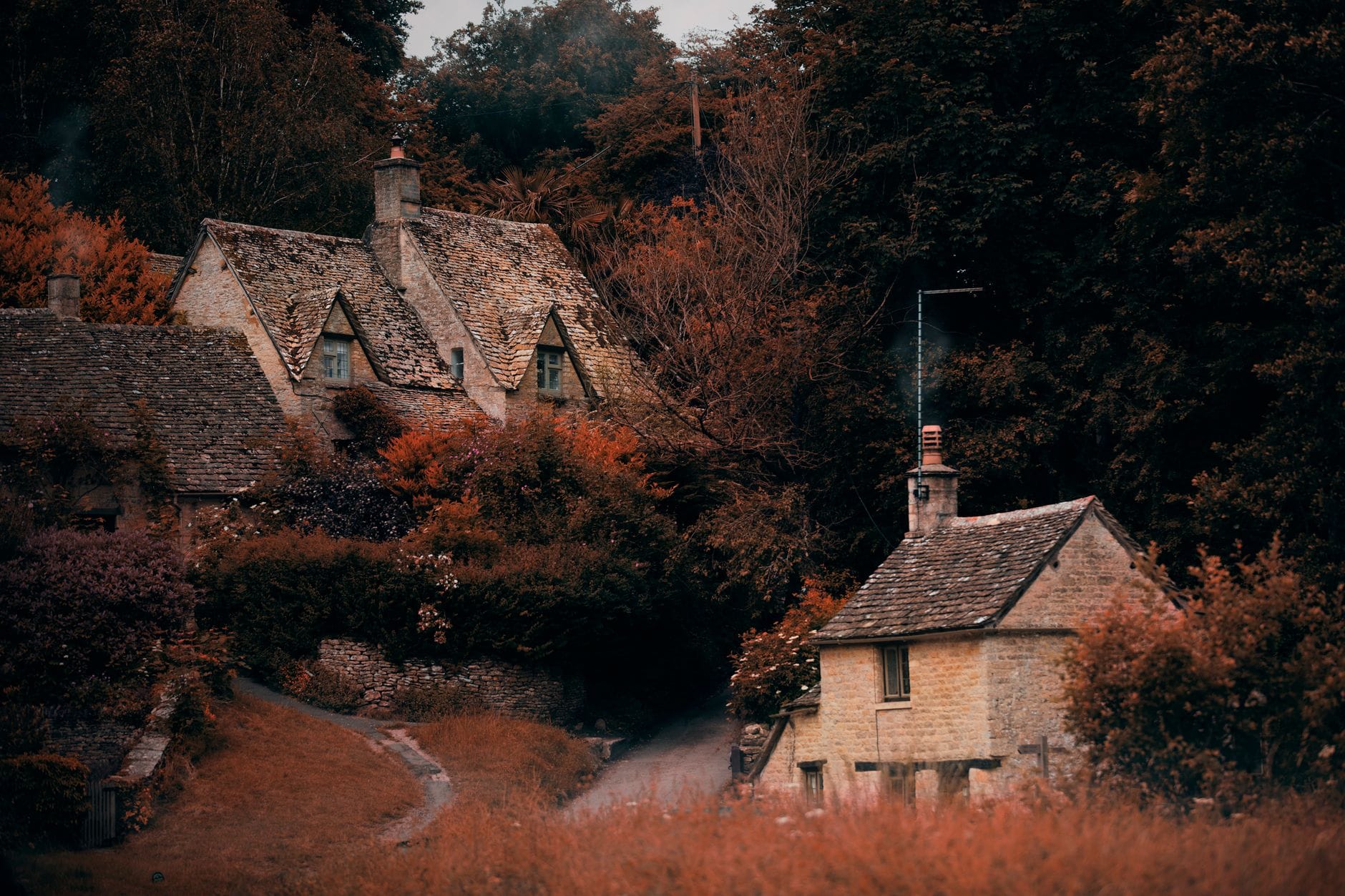 Stone weavers' cottages with autumn foliage in Bibury, the Cotswolds