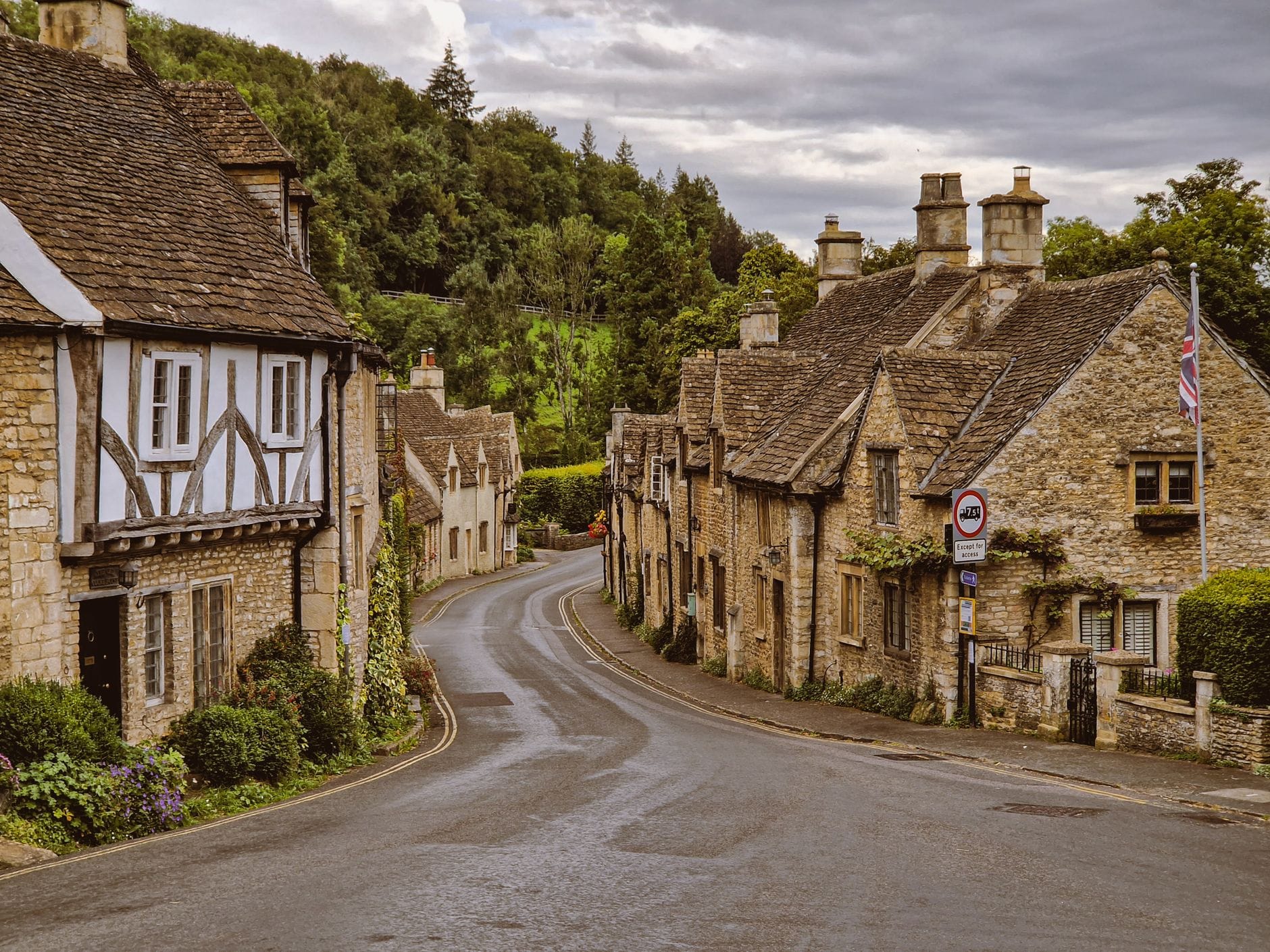Medieval stone cottages and church tower in Castle Combe village