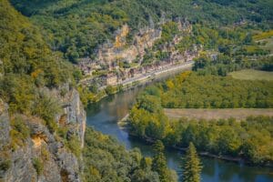 Aerial view of the Dordogne river winding past La Roque-Gageac, a highlight of any Dordogne on a budget trip