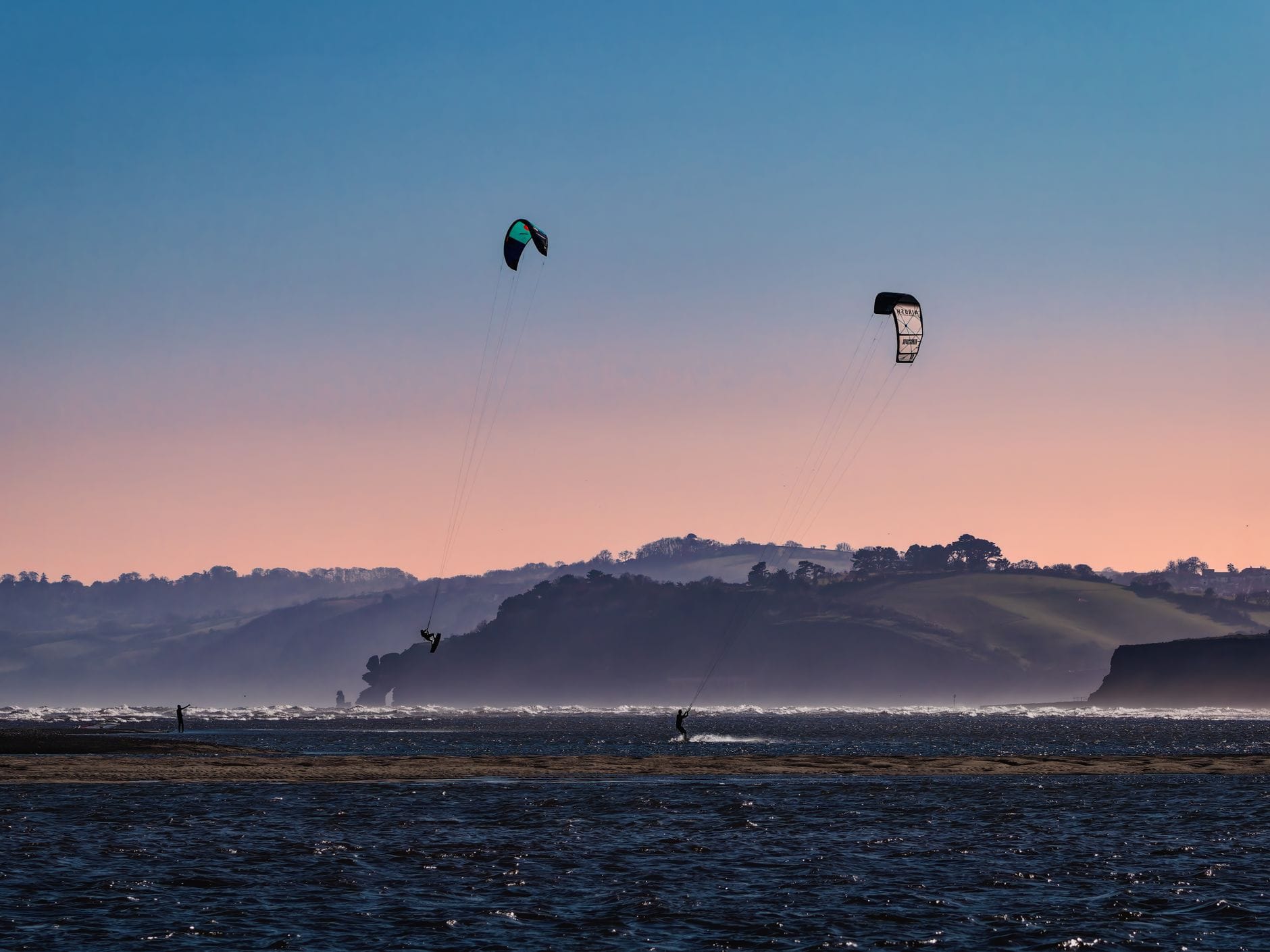 Kitesurfers at sunset on Exmouth beach, Devon