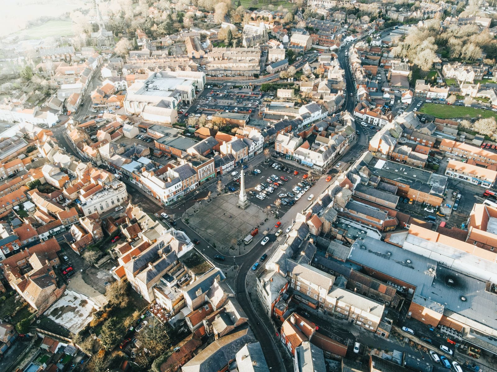 Aerial view of a historic UK market town with traditional buildings, similar in character to Carnforth's town centre