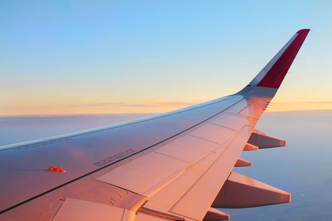 An aircraft wing against a sunset sky on approach to a Jet2holidays destination