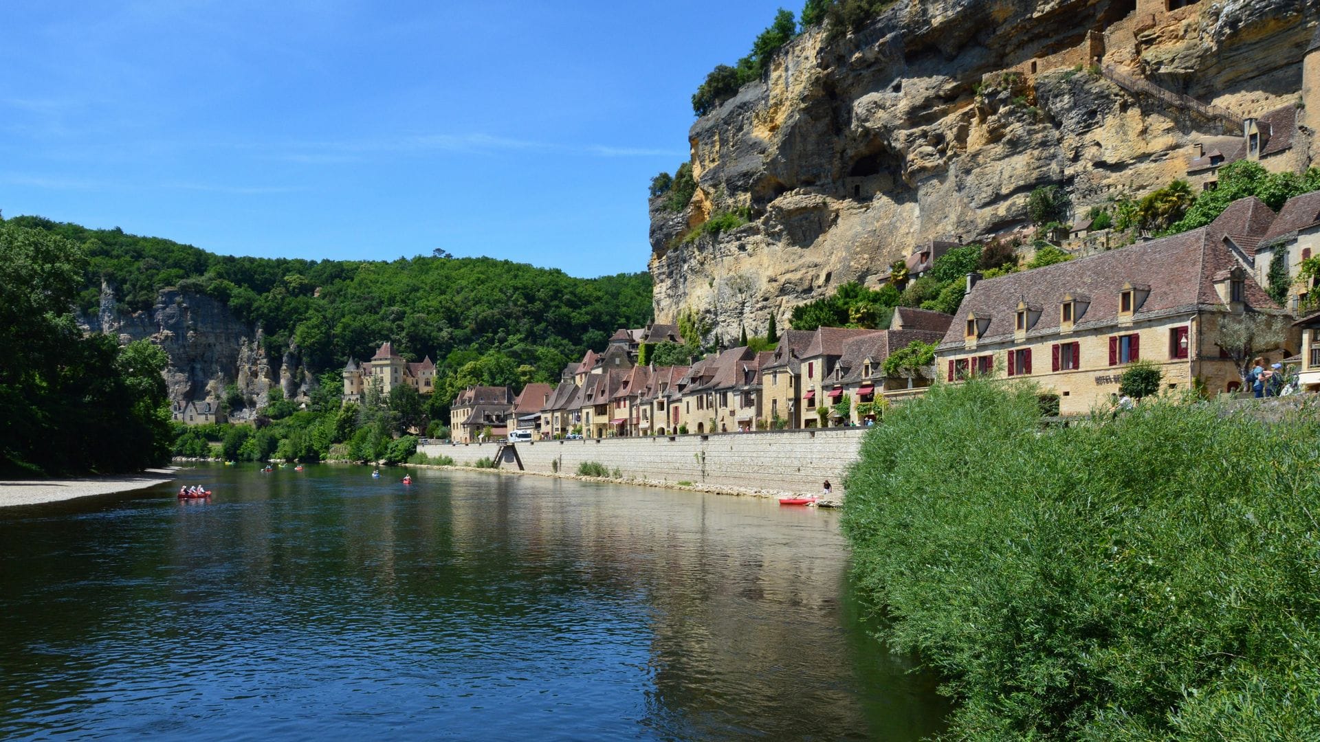 Canoes on the Dordogne river below the cliffside village of La Roque-Gageac