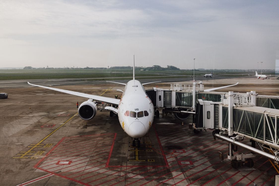 A jet airliner docked at an airport terminal gate, ready for boarding