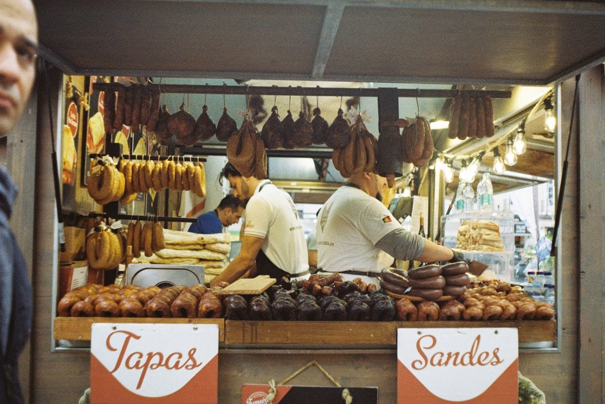 A Lisbon food market counter piled with fresh seafood and meat, the kind of local spot that beats a tourist restaurant