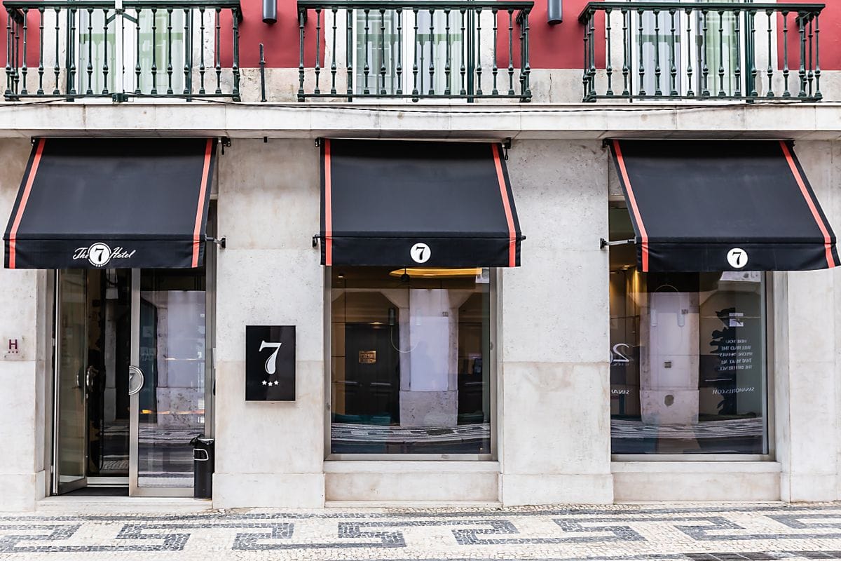 Elegant hotel facade in central Lisbon with balconies and awnings, typical of the city's boutique accommodation