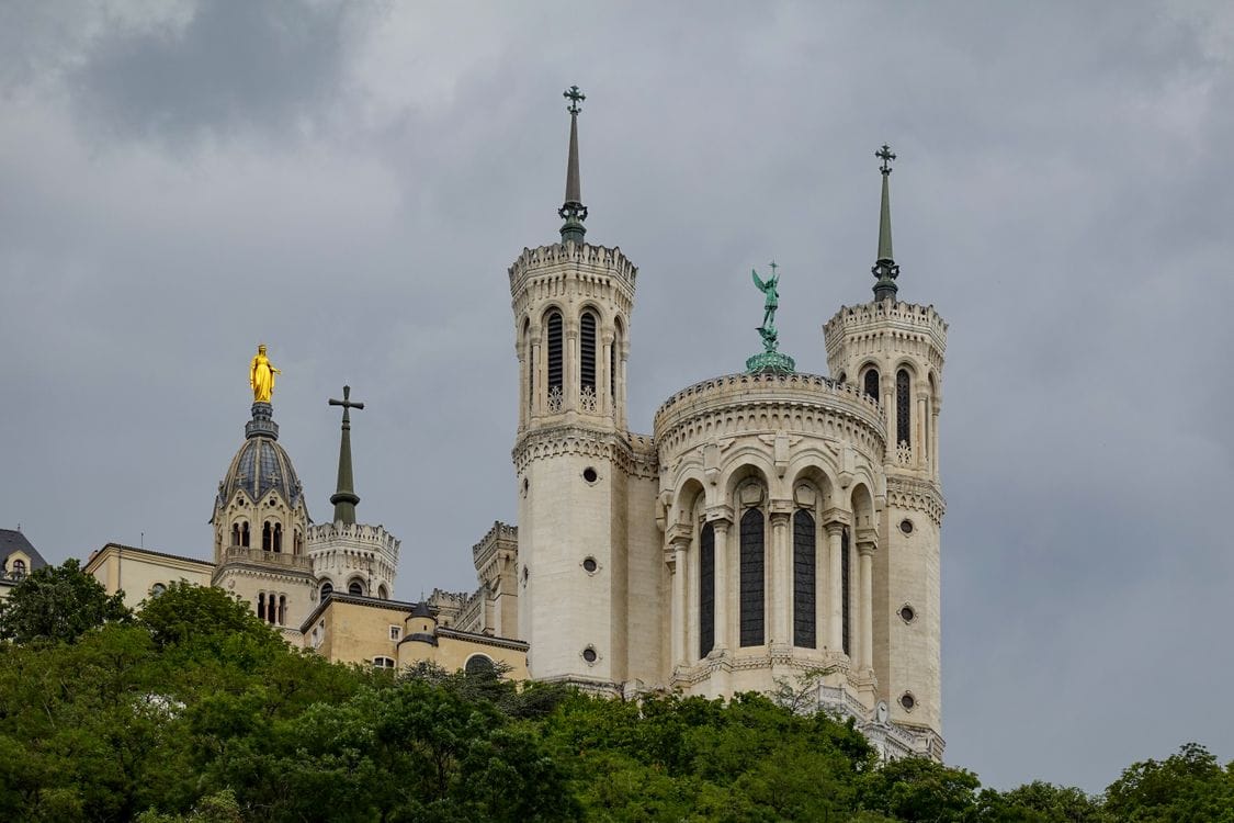 Close view of the Basilica of Notre-Dame de Fourviere with its golden statue against the sky
