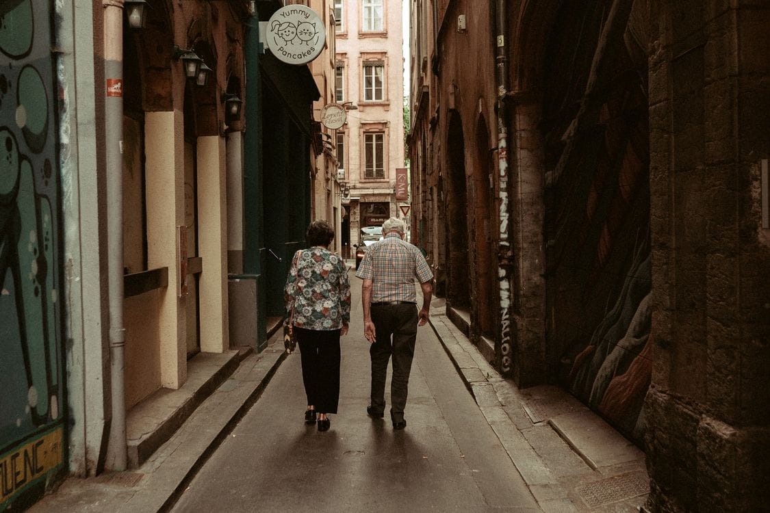 A couple walking through a historic covered passage in Lyon's old town