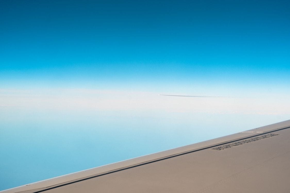 Aircraft wing above the clouds, representing a Norwegian route recently opened for booking