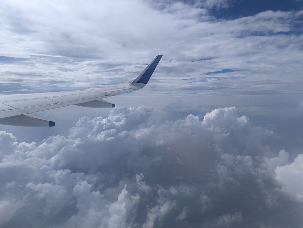 Aircraft wing over clouds, representing a Norwegian sale-period departure