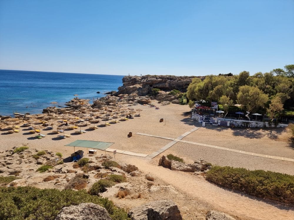 A sandy beach with sun loungers and umbrellas in Rhodes, Greece, a popular On the Beach destination