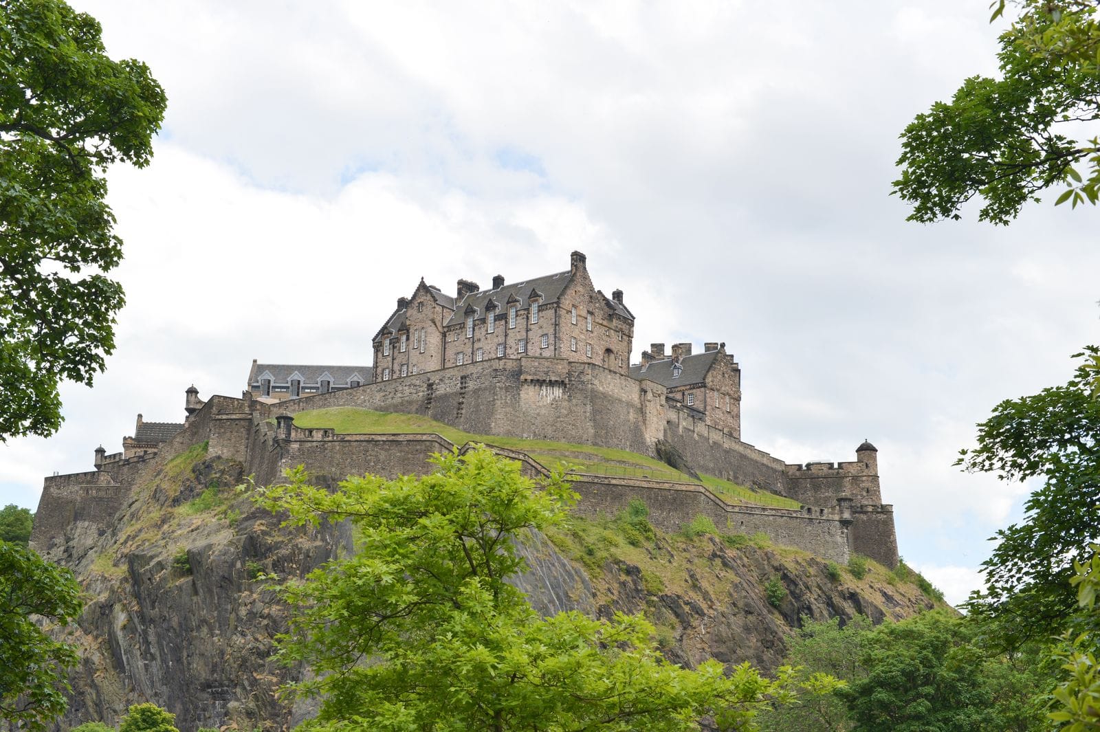 Edinburgh Castle perched on Castle Rock, framed by trees in the Old Town