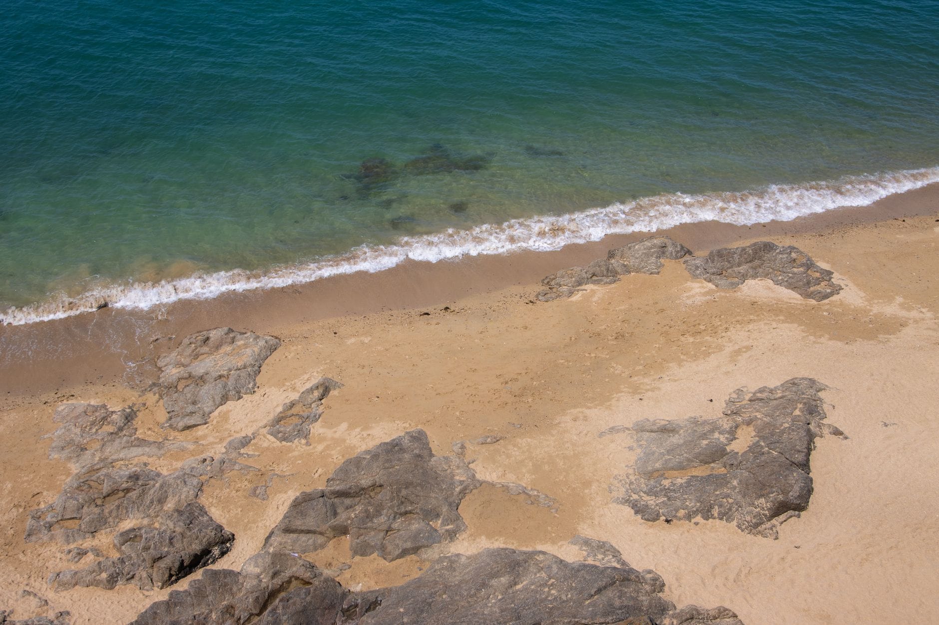 A sandy beach exposed at low tide near Saint-Malo, where paths to the tidal islands open up