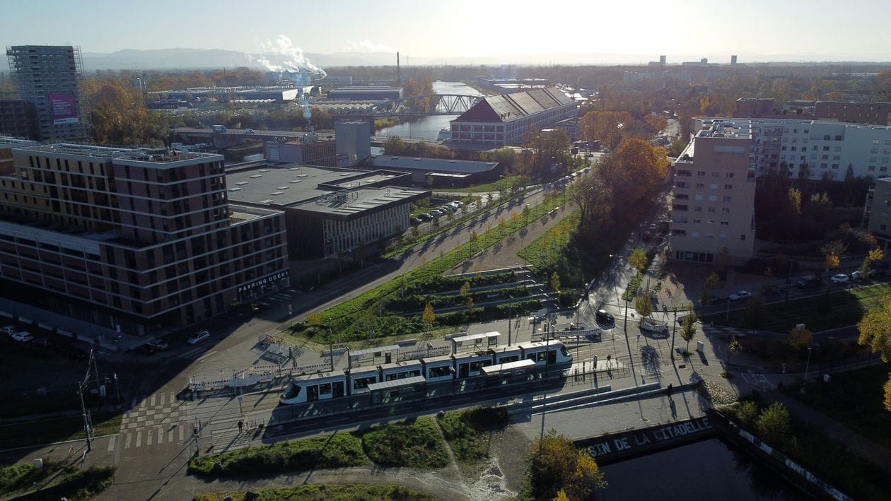 A Strasbourg tram crossing the city with autumn trees lining the route