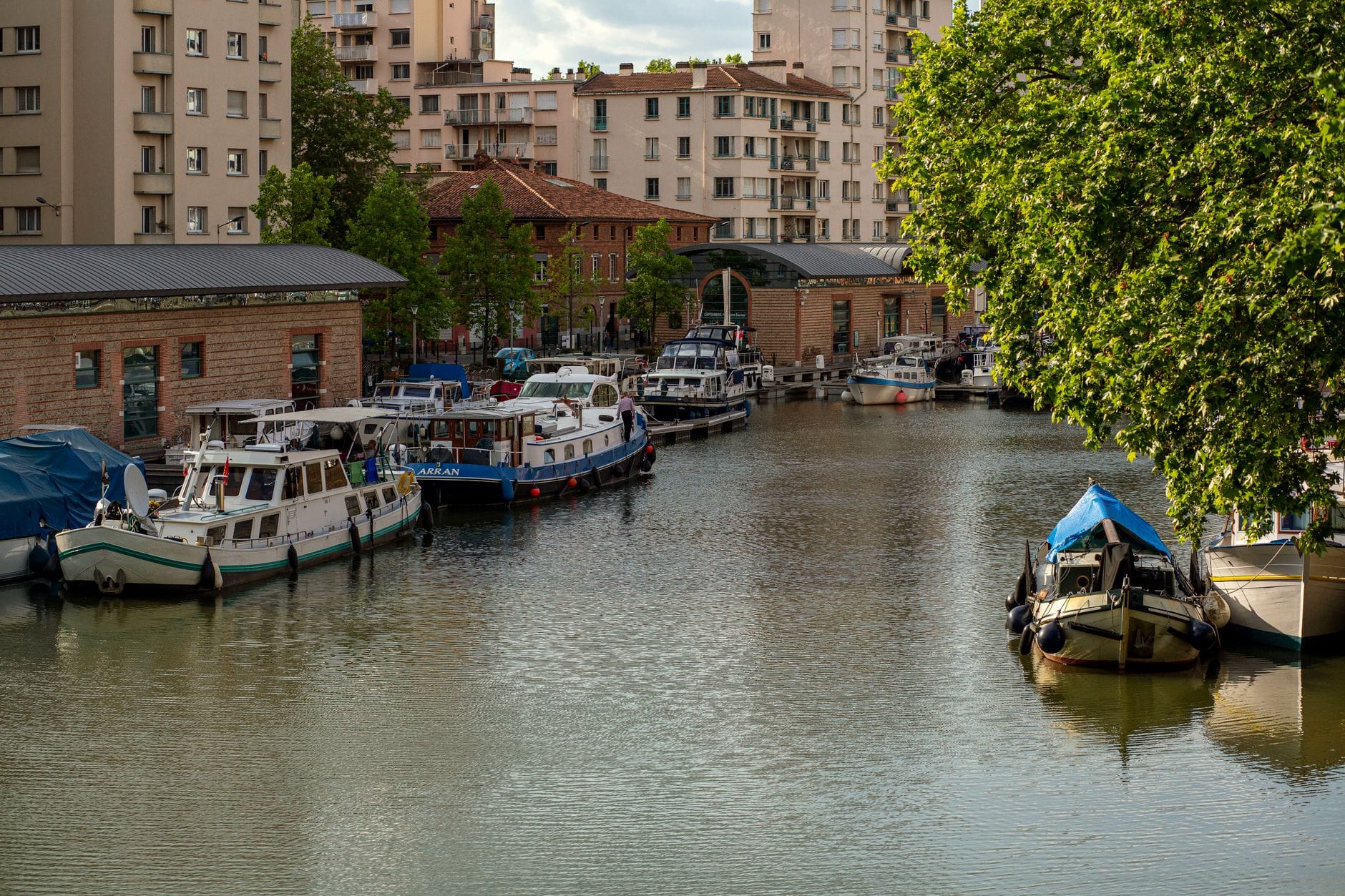 Houseboats moored along the tree-lined Canal du Midi in Toulouse