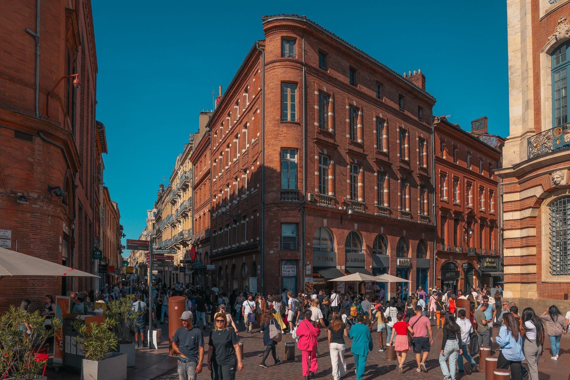 A busy pink-brick shopping street near Place du Capitole in Toulouse old town