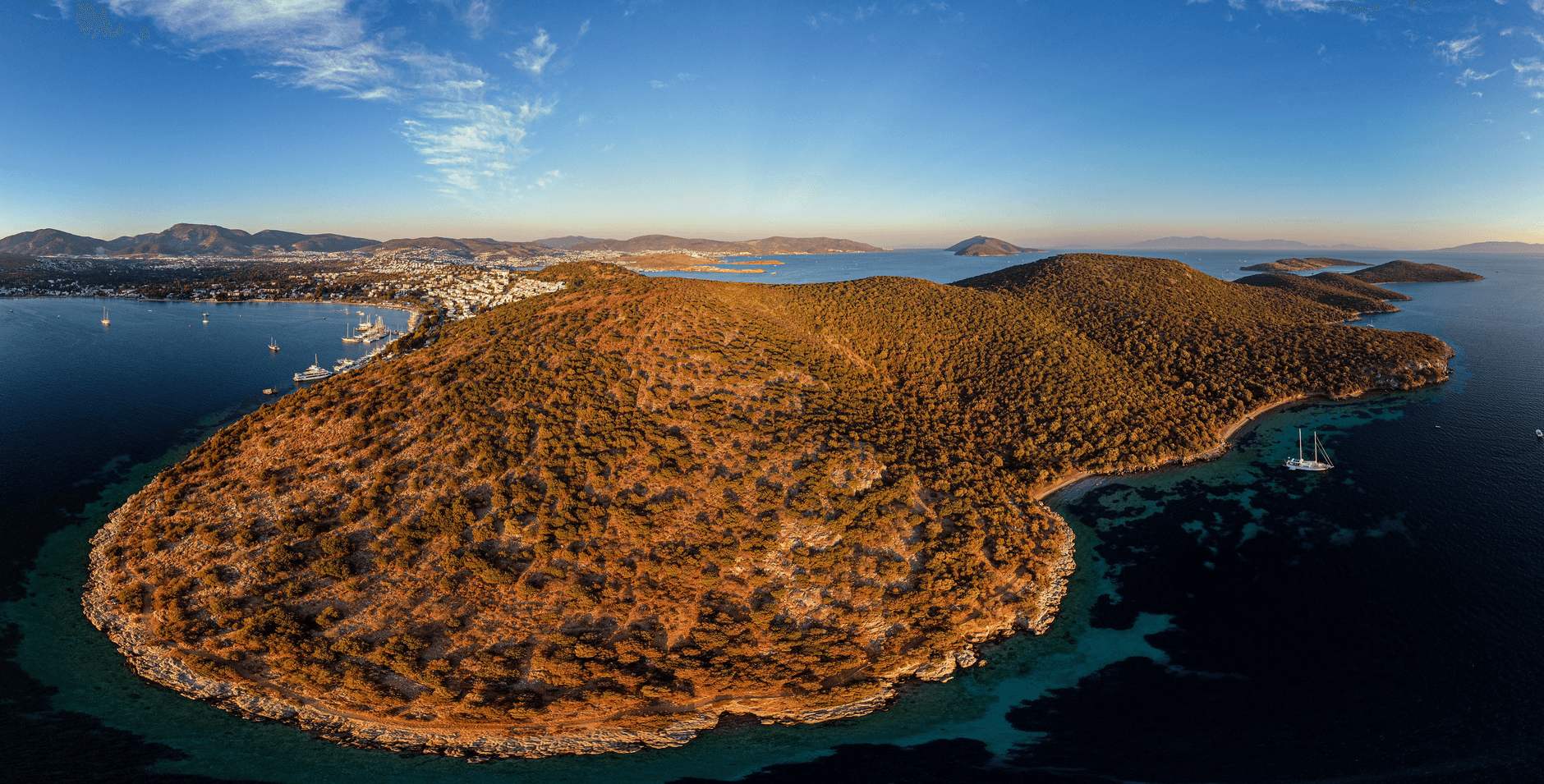 Aerial view of the Bodrum peninsula coastline with pine-covered hills and clear water, Turkey