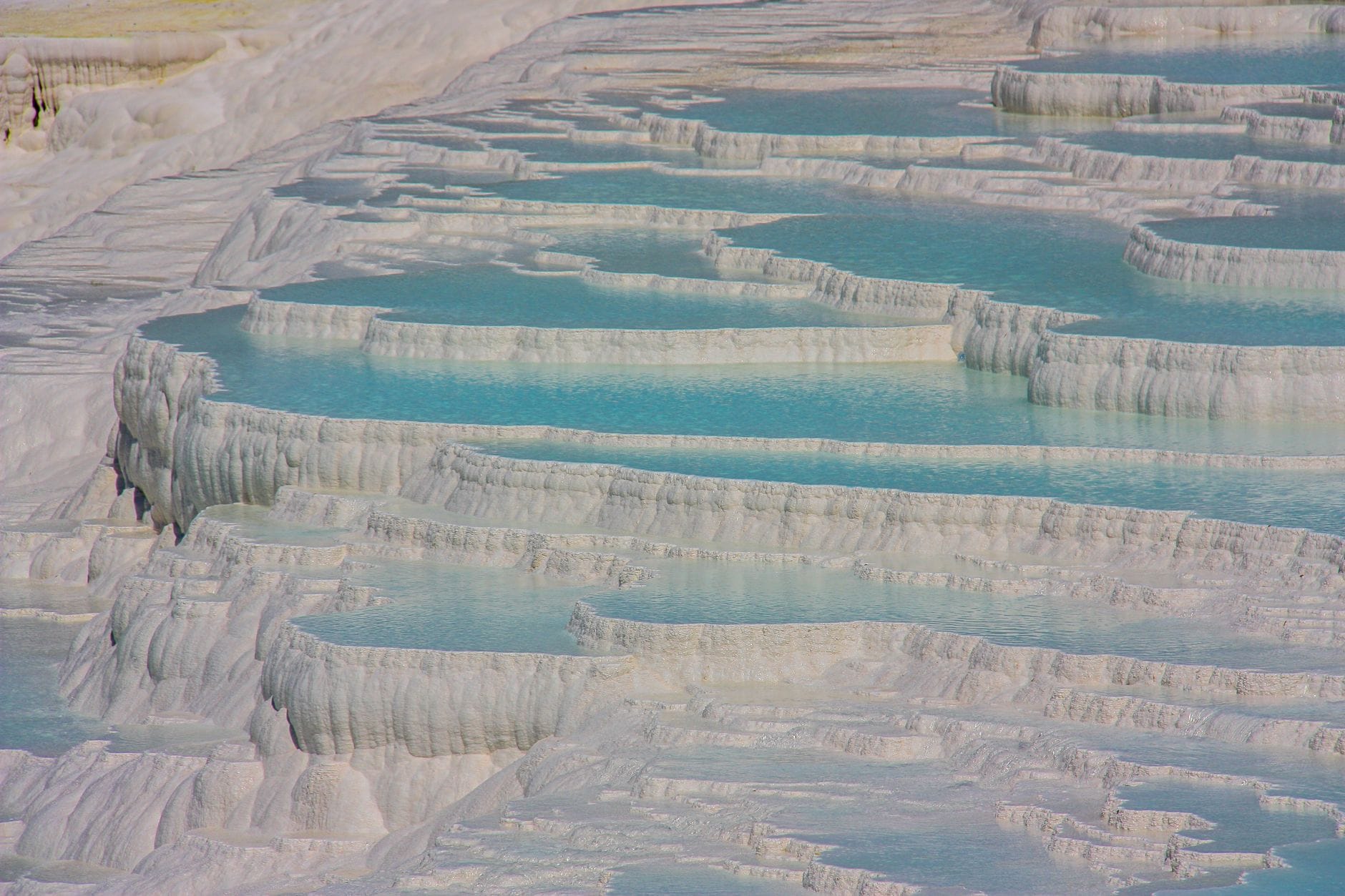 White travertine terraces and blue mineral pools at Pamukkale, Turkey