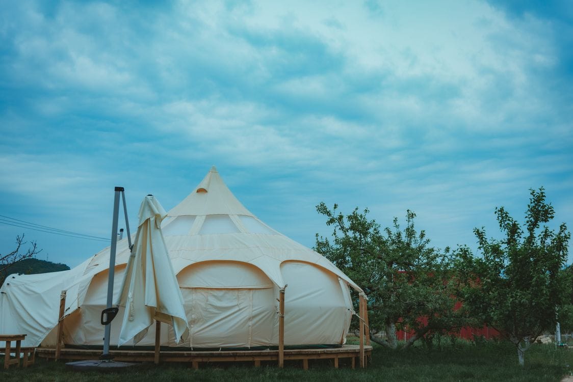 Cream glamping tent in a UK woodland clearing