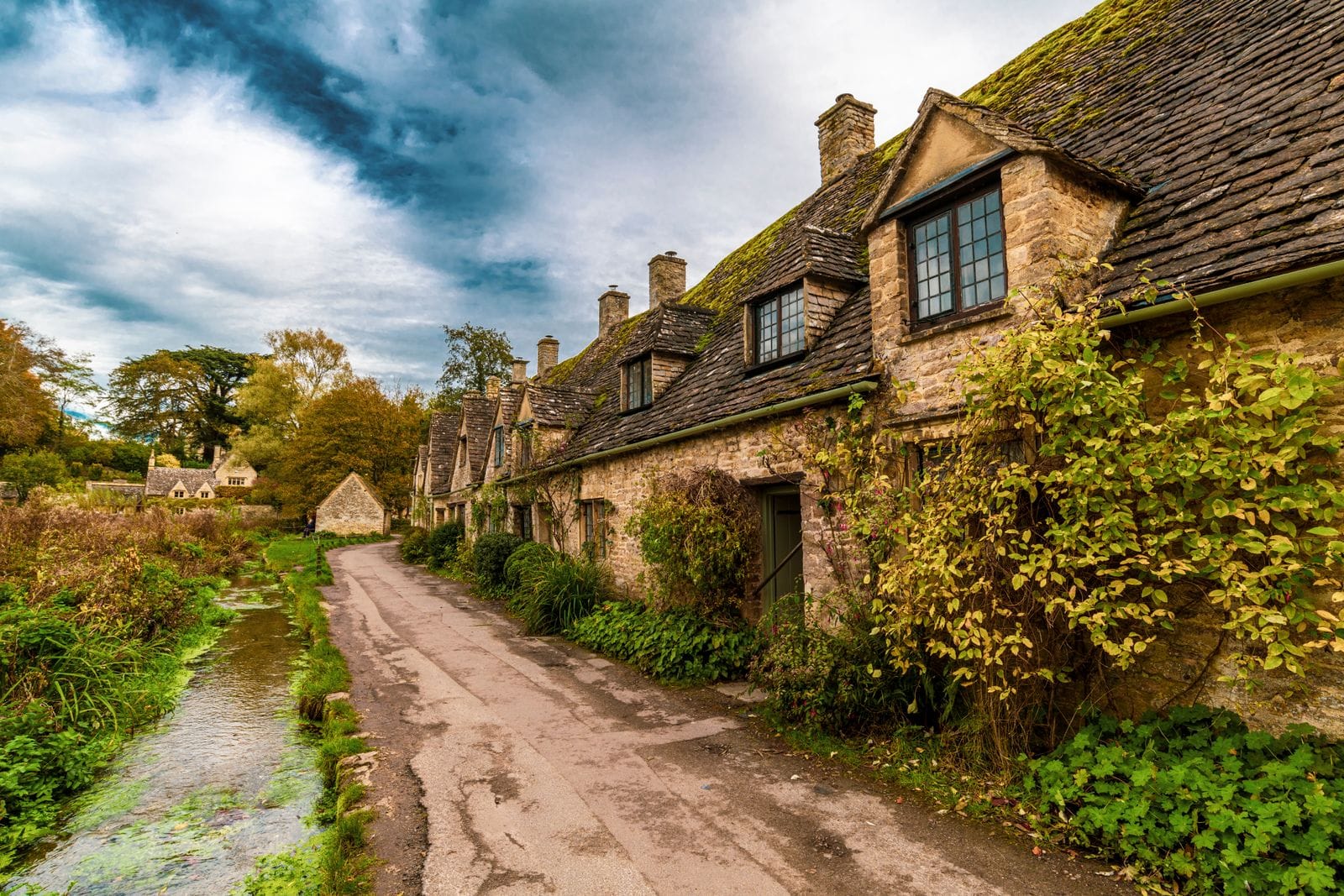 Historic stone cottages along a street in Bibury, the Cotswolds