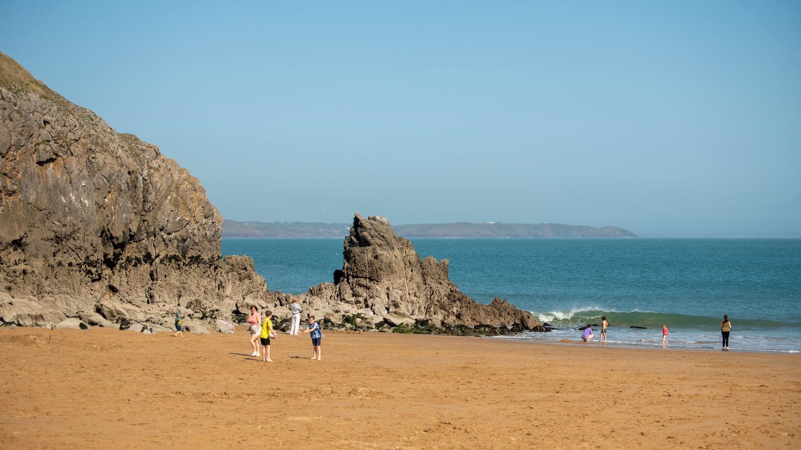 People enjoying a sandy beach on the Pembrokeshire coast