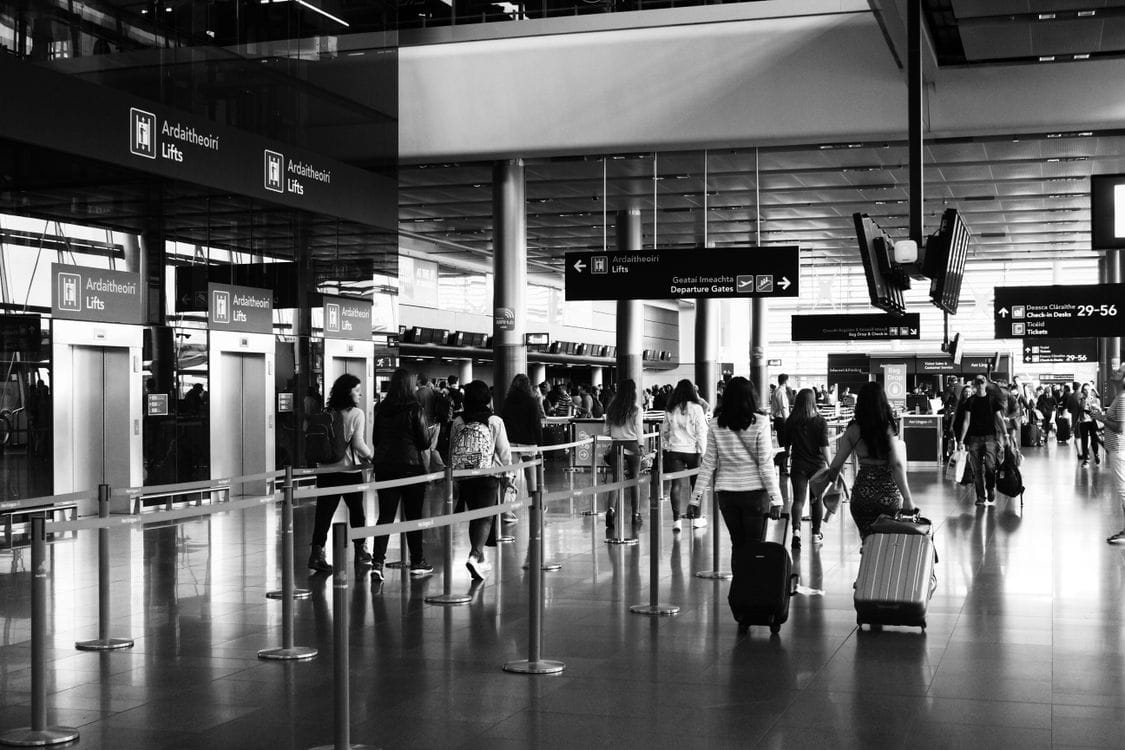 Travellers walking through an airport terminal with luggage during a Vueling flash sale period
