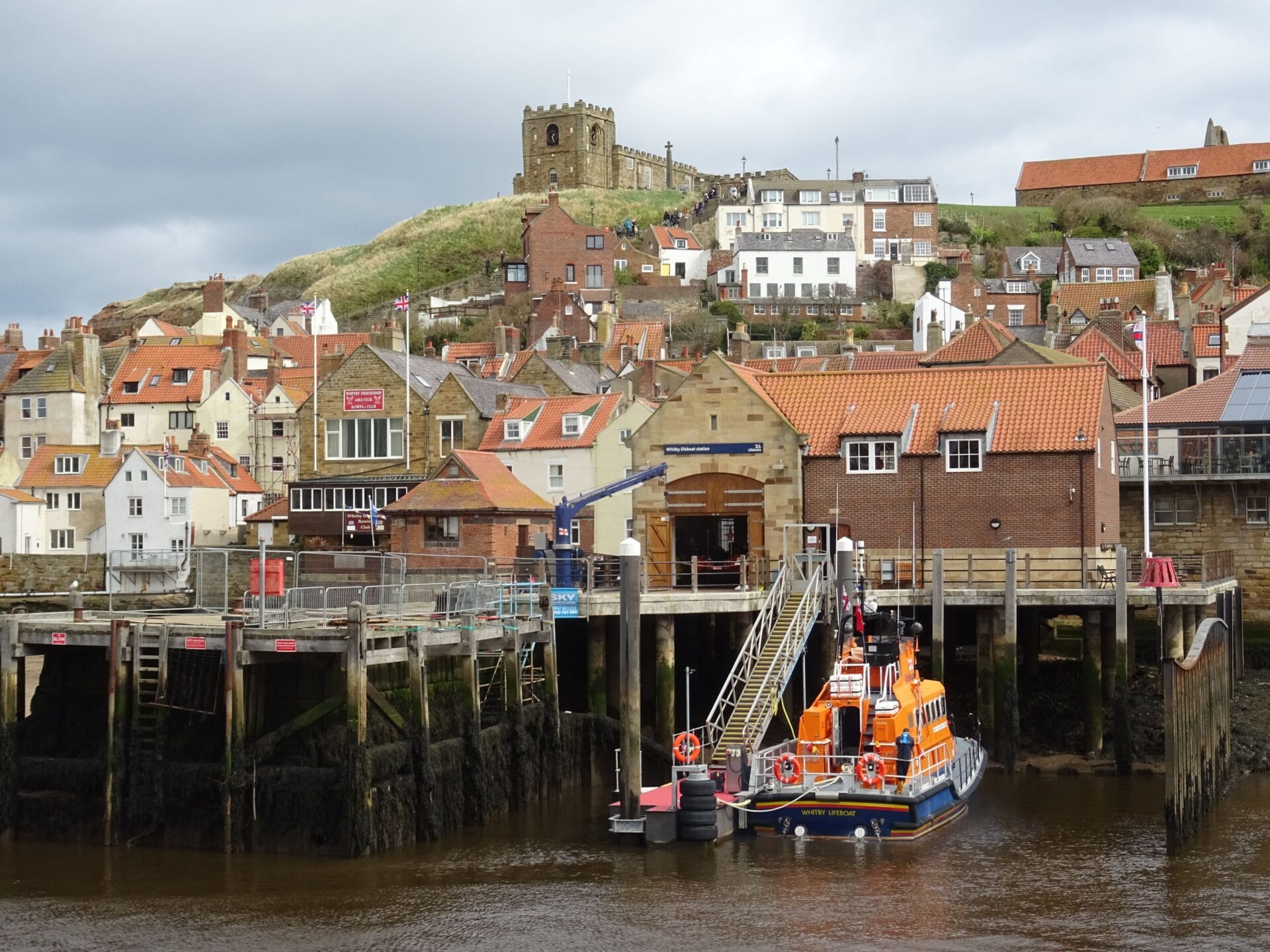 Whitby harbour with the RNLI lifeboat station and St Mary's Church on the headland above